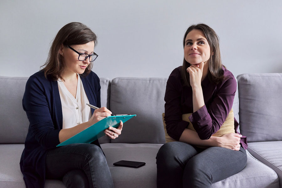 A licensed therapist taking notes on a clipboard during a private, one-on-one individual therapy session for addiction and mental health treatment. A licensed therapist taking notes on a clipboard during a private, one-on-one individual therapy session for addiction and mental health treatment.