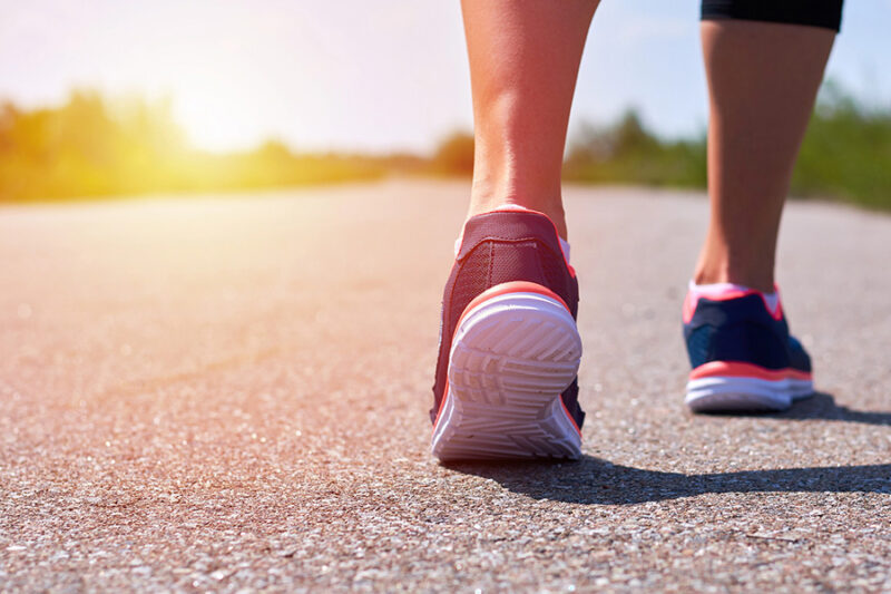 A person walking toward a bright horizon, representing the journey of recovery from addiction and a fresh start.