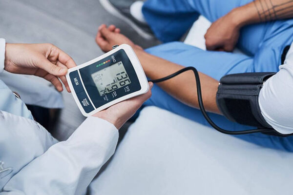Doctor taking the blood pressure of patient suffering from withdrawal symptoms from opiates