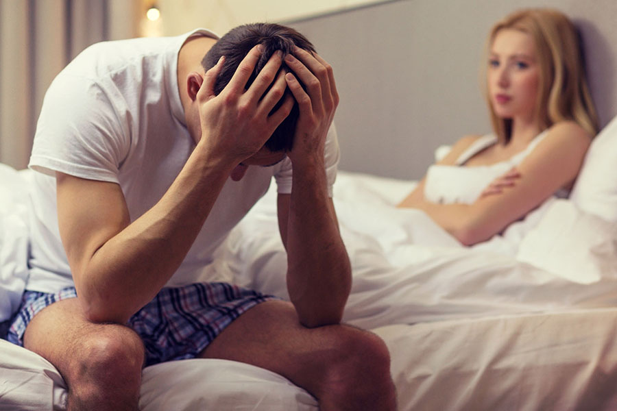 Male sex addict with hands on his head while wife is upset concept image of how to overcome sexual addiction.