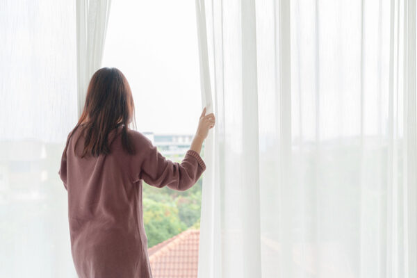 Opening windows to bright sunlight, a metaphor for the clarity found when leaving your environment for rehab.