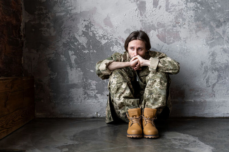 Soldier sitting on the floor suffering from PTSD symptoms concept image for AZ EMDR therapy and grief counseling