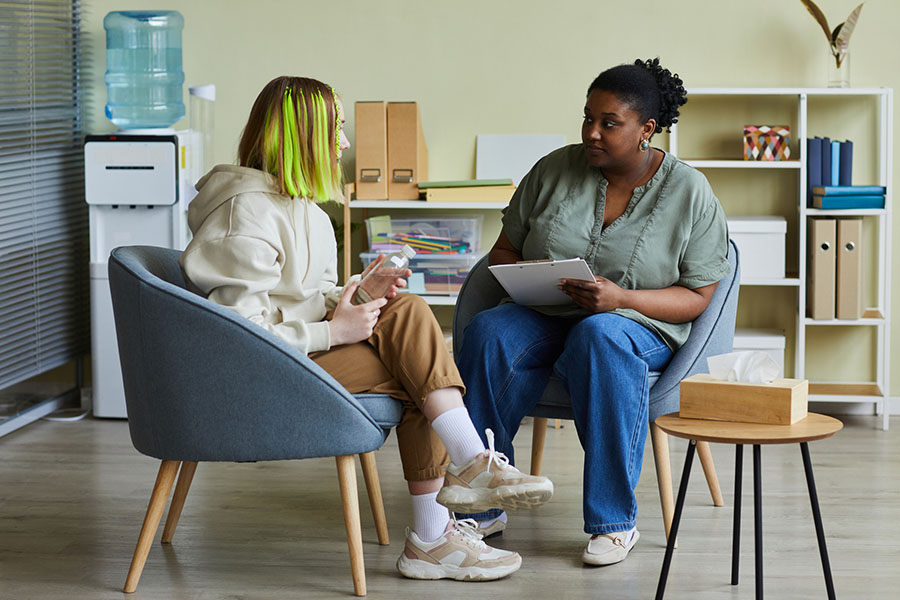 Female counselor discussing treatment options and behavioral health services with a rehab patient; exploring the benefits of PHP mental health treatment