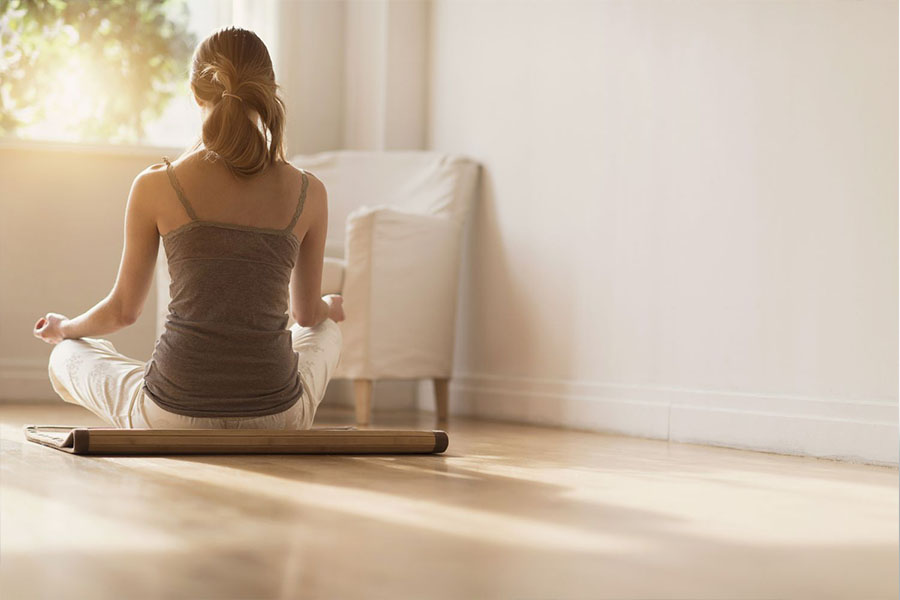 Woman practicing mindfulness and meditation at home - Promoting healing and resilience after childhood trauma for better mental health.