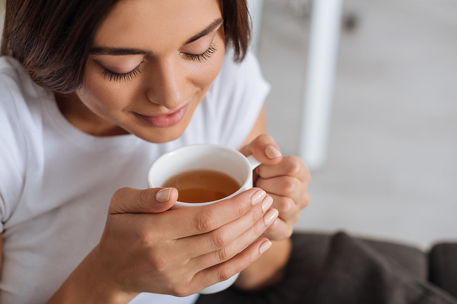 Young lady holding a cup of tea after practicing mindfulness