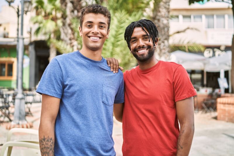 Two smiling friends standing together outdoors, representing connections that are often built during aftercare treatment