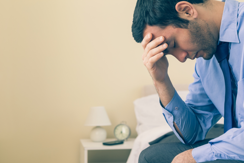 upset man with hand on his forehead after alcohol relapse