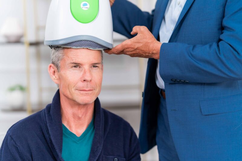 Man undergoing Transcranial Magnetic Stimulation session, representing the connection between autism and TMS