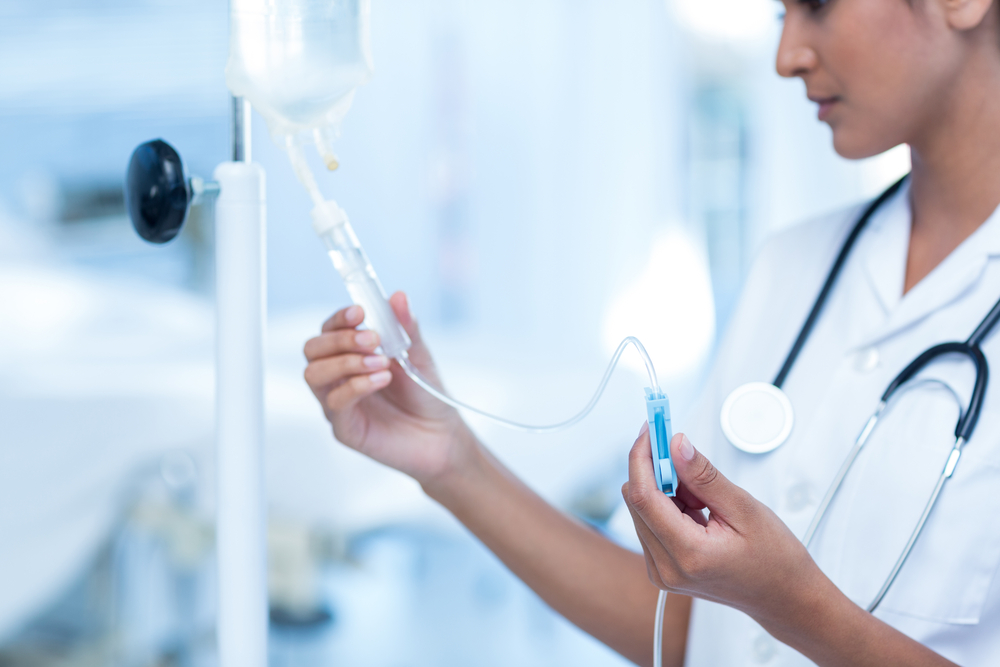 nurse connecting an intravenous ketamine infusion drip in hospital room