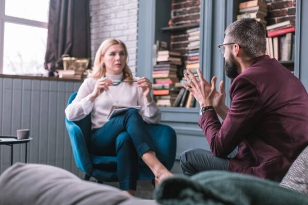 A man in a counseling session discussing emotional challenges and cocaine withdrawal symptoms with a licensed therapist in a private setting