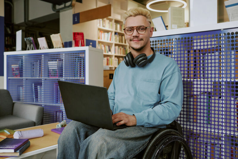 Student in a wheelchair using a laptop, representing inclusion of diverse needs from a list of neurodivergent conditions