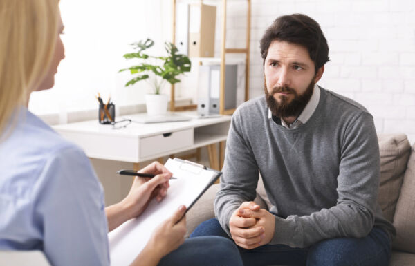 A man in a counseling session with a therapist, seeking support for prescription drug addiction recovery in a calm setting