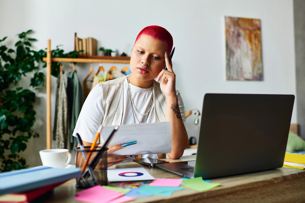 Illustrative concept of what falls under neurodivergent, showing a person working at a desk with a laptop